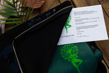 Good Mantra yoga mat care instructions card displayed with black yoga mat carrier bag.